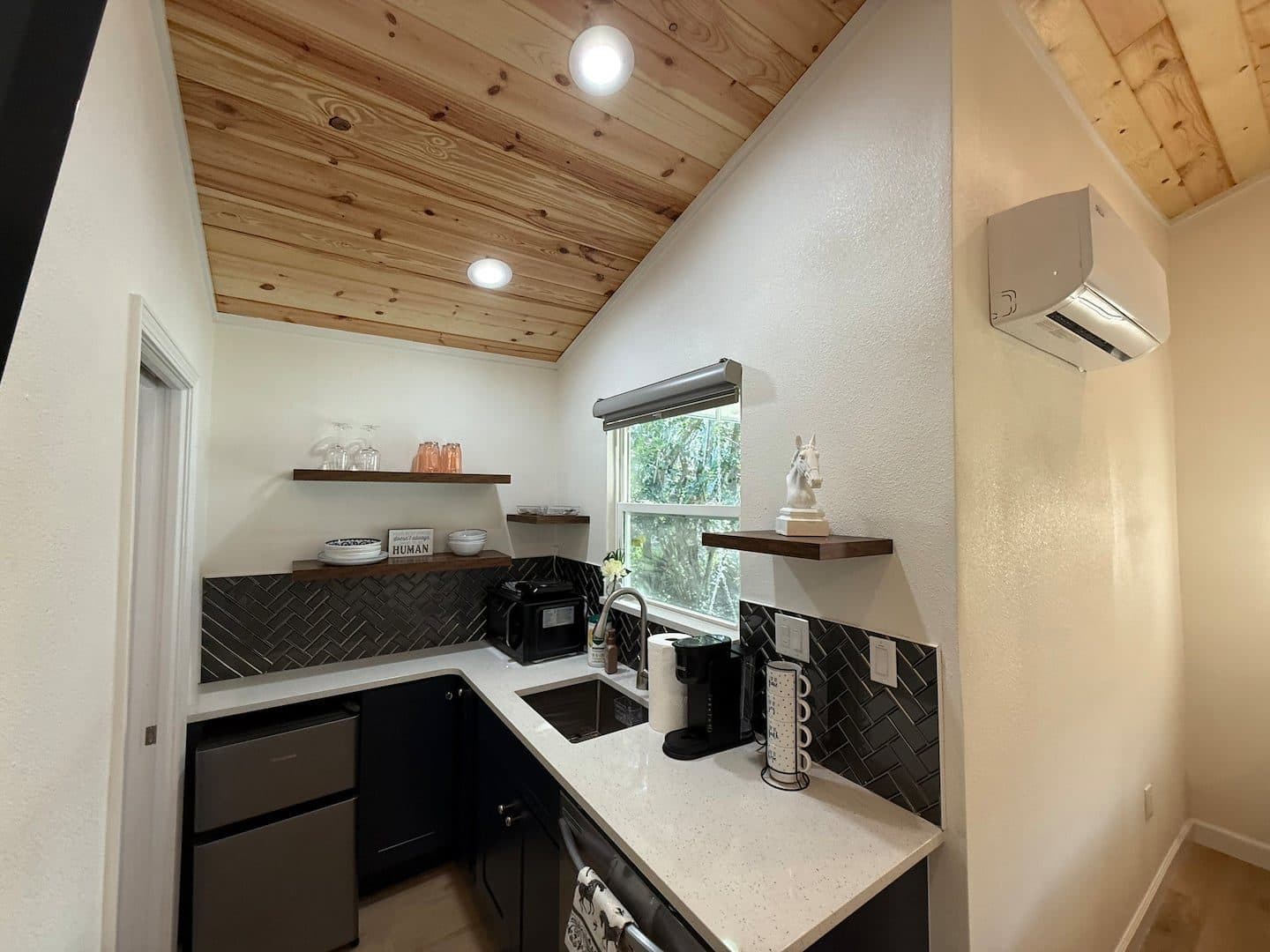 Kitchenette with a sink, mini fridge, coffee maker and open shelves