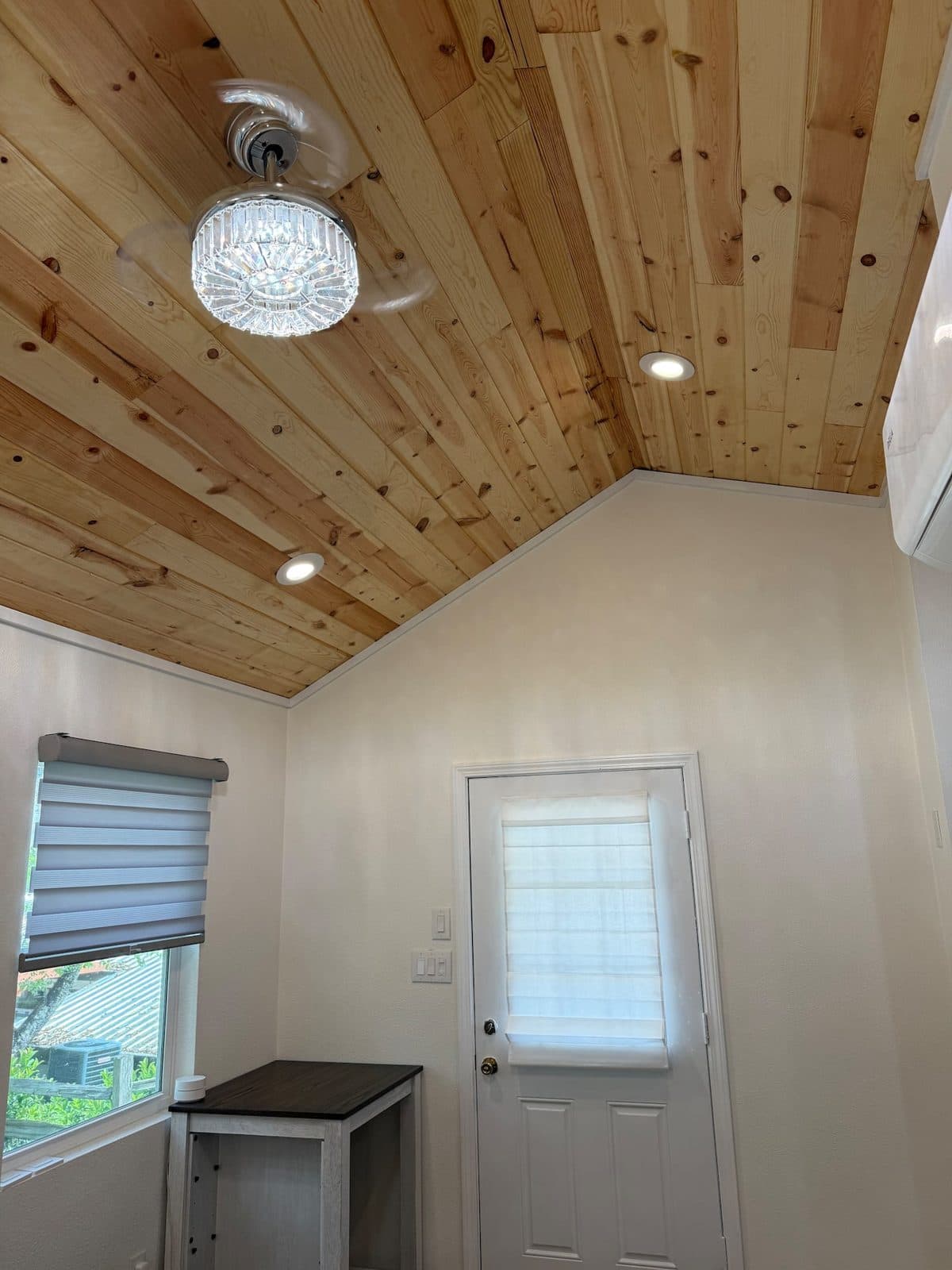 Front door and window under the wood ceiling and ceiling fan