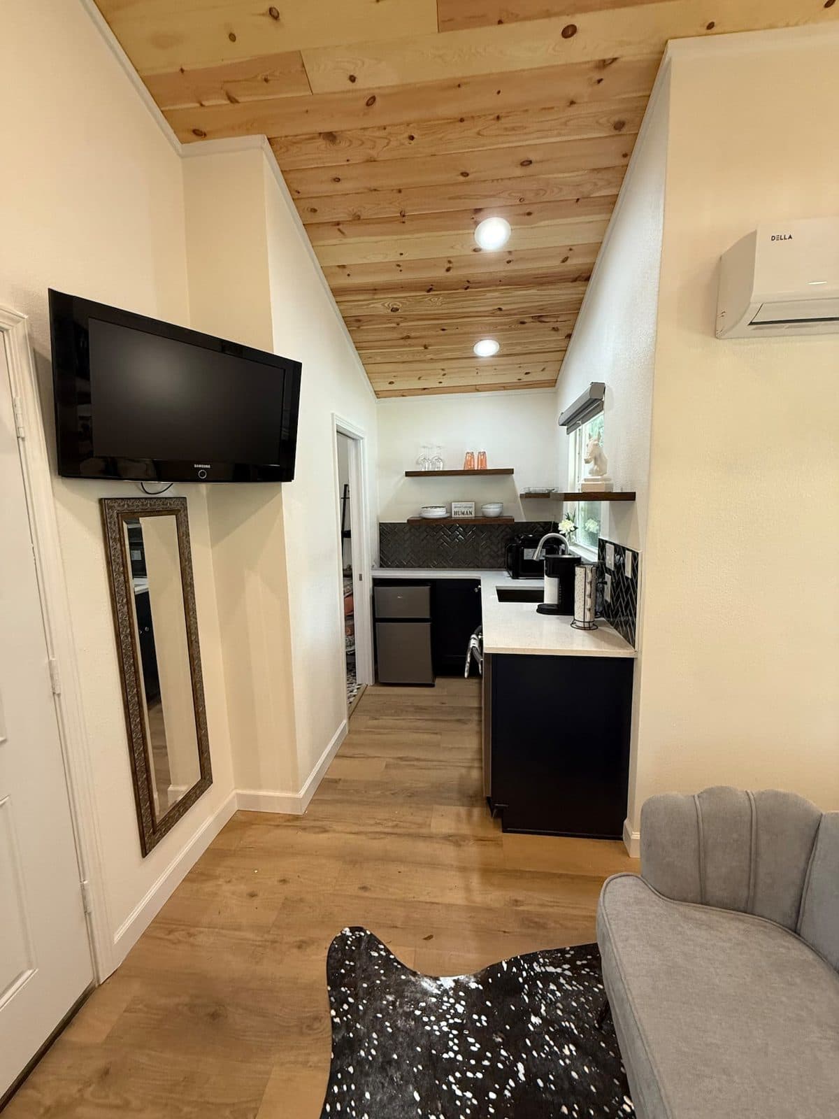 View along the cabin toward the kitchenette, with a wall-mounted TV