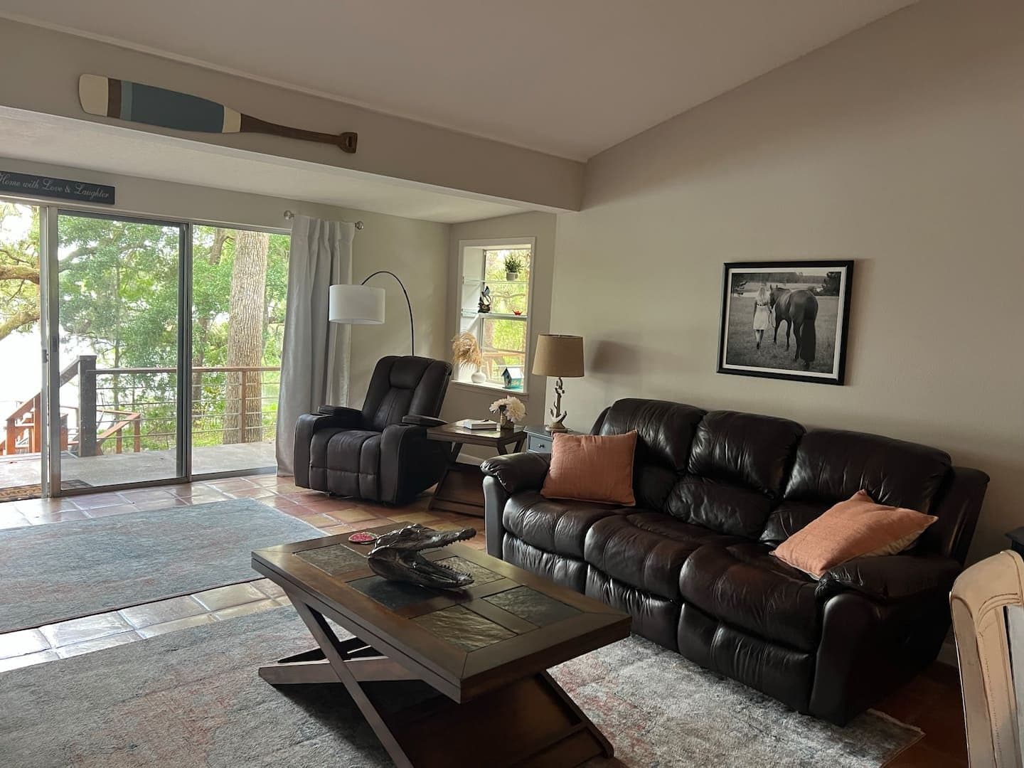 Living room with a leather sofa, recliner and sliding doors to the deck
