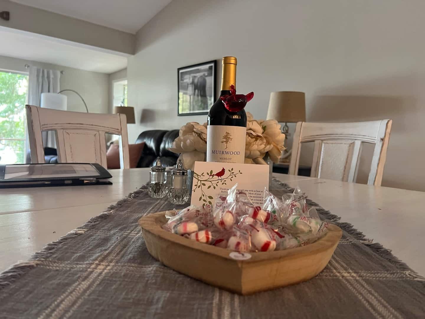 A bottle of wine and a bowl of peppermints on the dining table