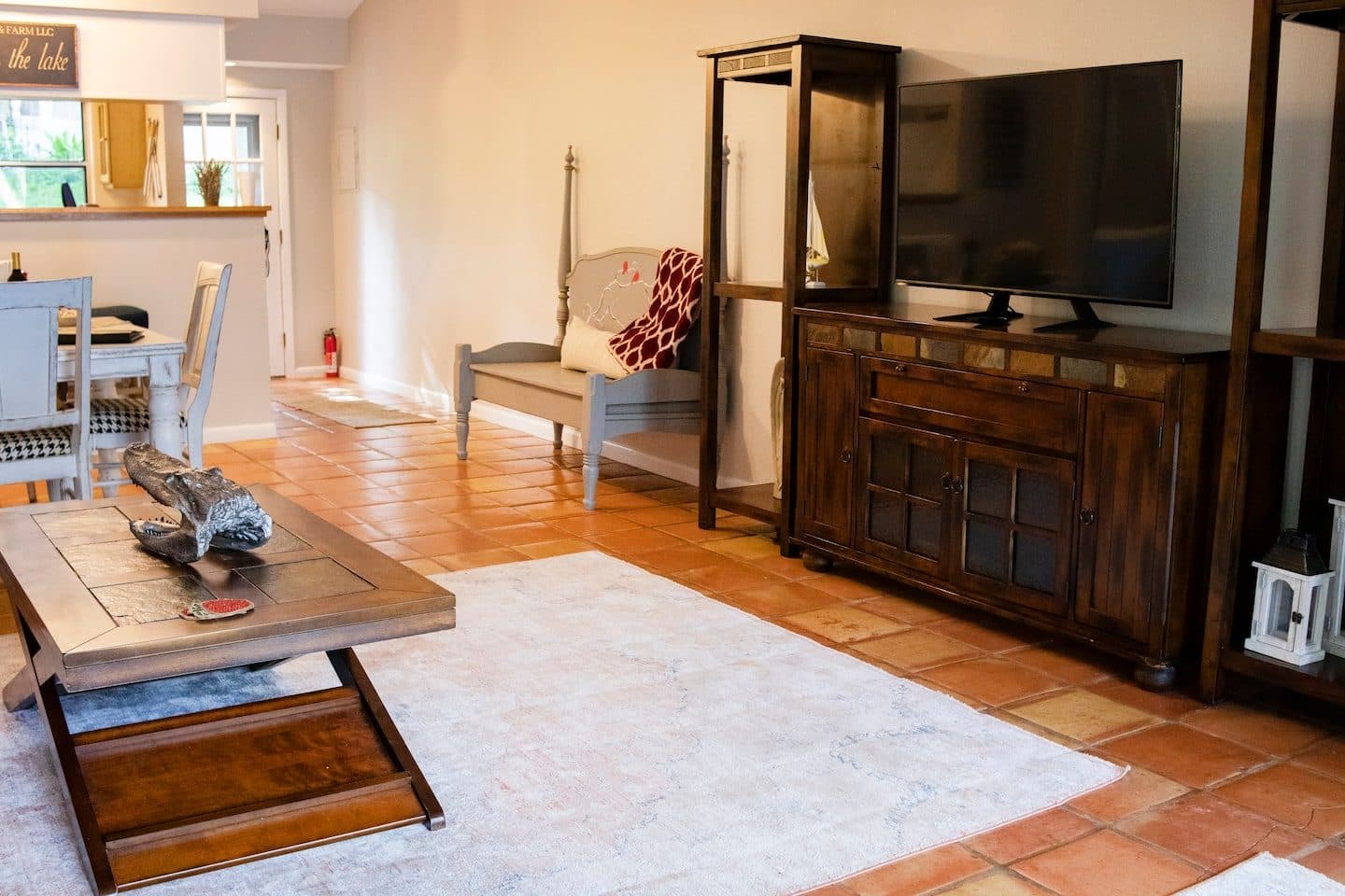 Living area with a TV cabinet, coffee table and tiled floor
